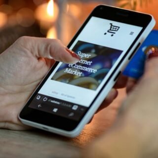 Seseorang sedang nyaman berbelanja online menggunakan smartphone dengan tampilan website e-commerce yang responsif dan rapi.