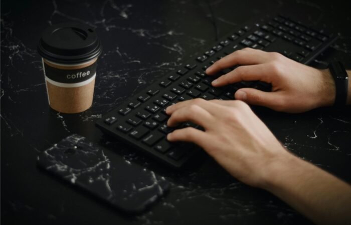 Seseorang sedang mengetik naskah deskripsi produk yang persuasif di laptop untuk halaman toko online.