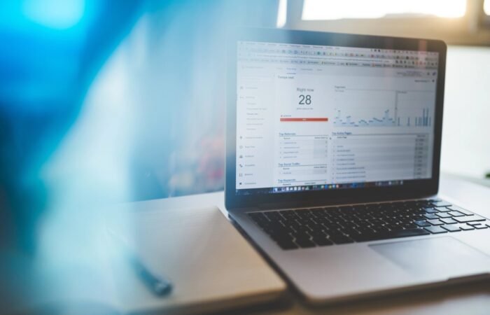 Seseorang sedang mempelajari grafik pertumbuhan pengunjung dan data demografi pada dasbor Google Analytics 4.