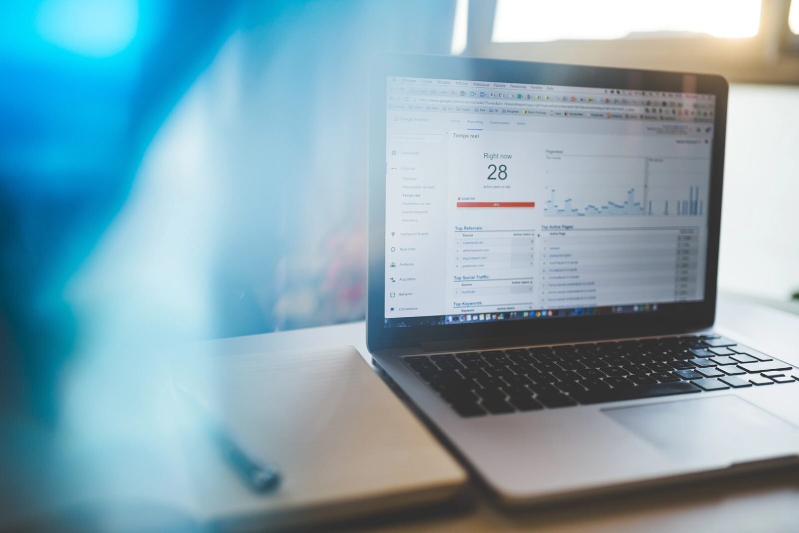 Seseorang sedang mempelajari grafik pertumbuhan pengunjung dan data demografi pada dasbor Google Analytics 4.