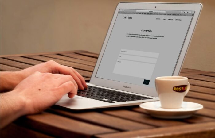 Seseorang sedang mengelola ketersediaan kamar dan pemesanan otomatis melalui dasbor website manajemen kos di perangkat tablet.