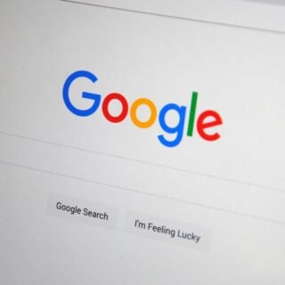 Seseorang sedang menganalisis grafik kenaikan trafik organik di halaman pertama pencarian Google pada layar monitor.